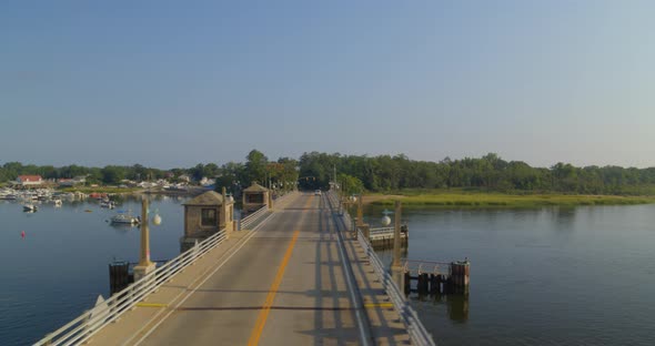 Rising Aerial Pan of a Drawbridge Over Water and Near a Forest in Long Island