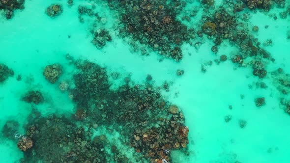 Seawater texture. Crystal clear water, sandy seafloor with corals and stones, Aerial descending