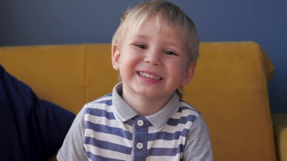 Portrait Of Playful Cheerful Little Blond Kid Looking At Camera And Smile