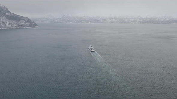 Ferry en route from Olderdalen to Lyngseidet on foggy Kaafjord, Norway; drone