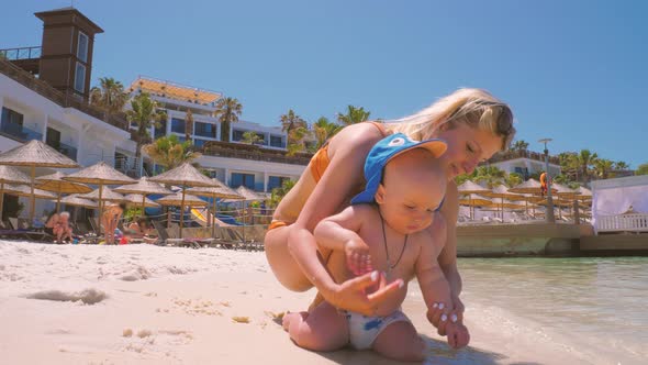 For the First Time, a Child Near the Ocean with His Mother Touches Salt Water 