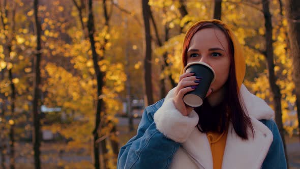 Young Woman Drinking Coffee in Autumn Forest