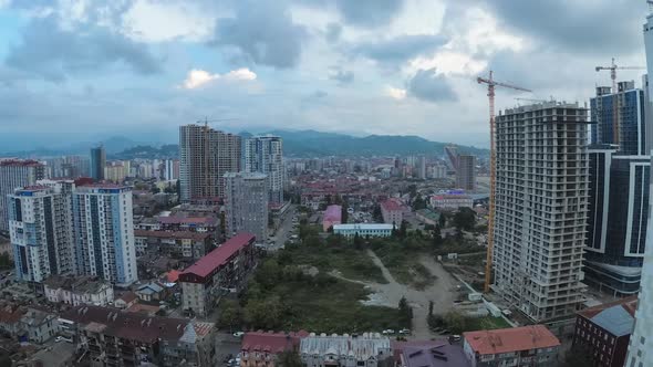 From Day To Night City Space with Construction Site, Skyscrapers, Traffic, and Mountains. Timelapse