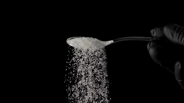 Sugar in a Spoon on Isolated Black Background
