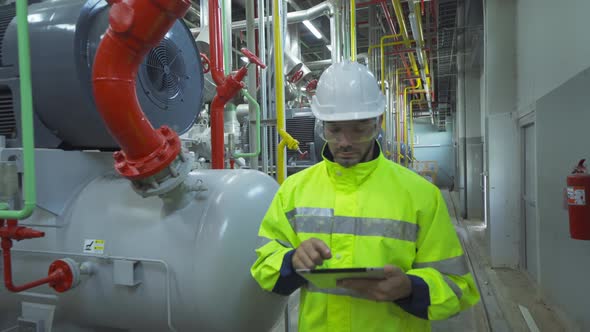 An engineer man or worker, people using a tablet device, working in industry factory. Chiller tower