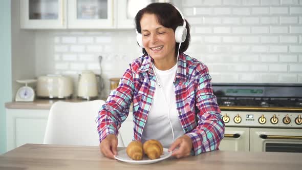 American Happy Mature Woman Dancing with Food in Home Kitchen