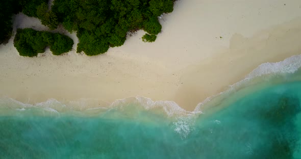 Luxury flying abstract shot of a white sandy paradise beach and blue ocean background in vibrant 4K