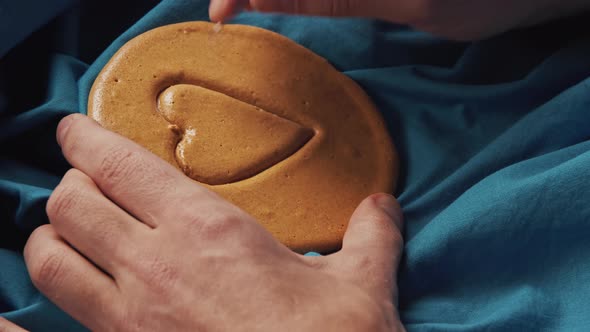 Men's Hands Scratch Sugar Cookies Candy in the Shape of a Heart