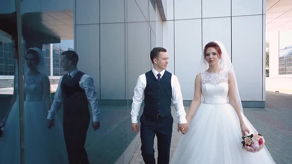 Newlyweds Walk Along the Glass Building Slow Motion