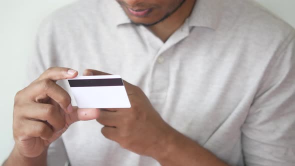 Thoughtful Young Man Hand Hold a Credit Card