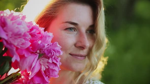 Closeup Portrait Woman with Long Hair with a Bouquet of Peonies