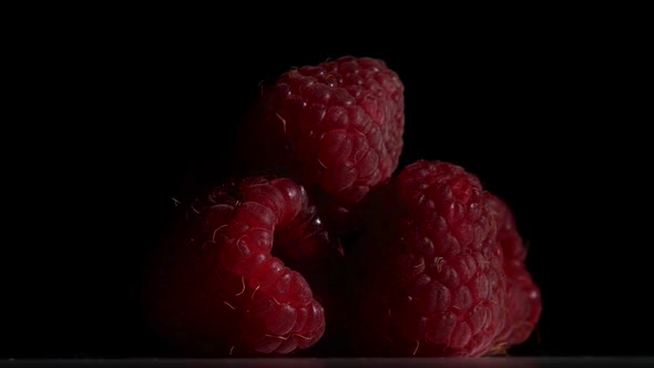 Raspberry Fruit Is Revolve on a Black Background. Close Up