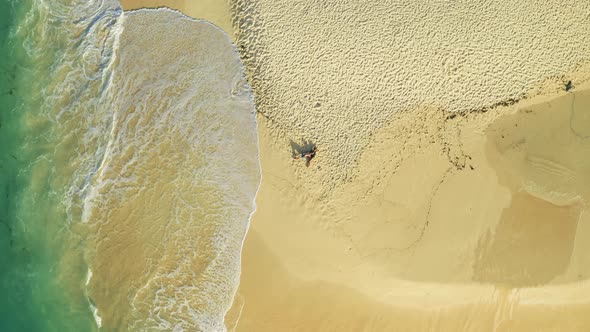 Aerial Top View of Couple Lying on White Sand Beach and Azure Sea in Tropical Daku Island Beach