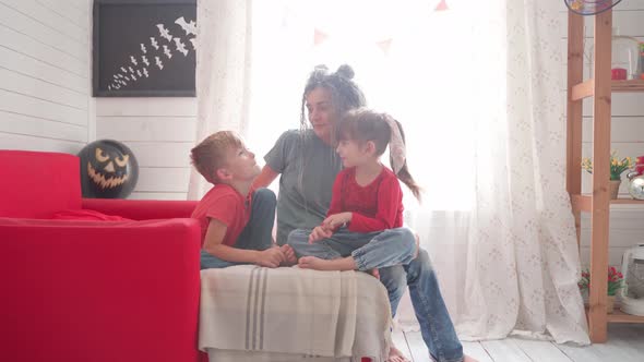 Children with Their Mother Decorate the Room for Halloween