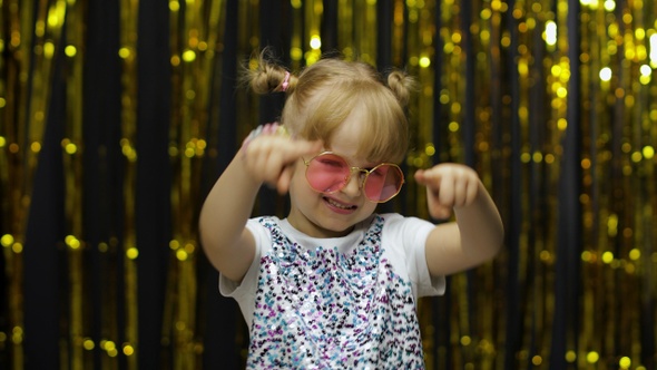 Child Kid Dancing, Celebrating Victory, Fooling Around. Girl Posing on Background with Foil Curtain