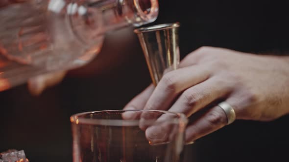 Bartender Measures Alcohol with Jigger and Pours Into Glass