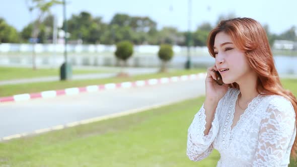 panning shot of Woman calling on the mobile phone in public park