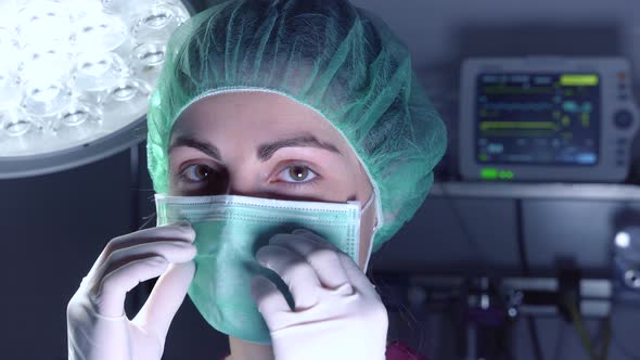 Adult Woman in Medical Mask and Hat Looking and Smiling at Camera Before Performing Surgery in