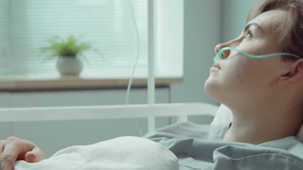 Young Woman with Nasal Cannula Lying in Hospital Ward