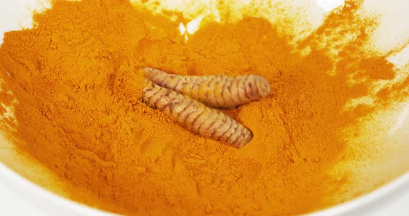 Turmeric, curcuma longa, Root falling on curcuma Powder, Indian Spice, Slow Motion 4K