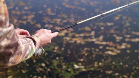 Man reeling in spinner fishing rod. High Speed/Slow Motion