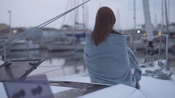 Beautiful Redhaired Woman Sitting in a Plaid on a Yacht in the French Port