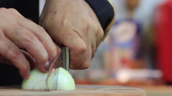 The Hands Cutting Onions on a Board