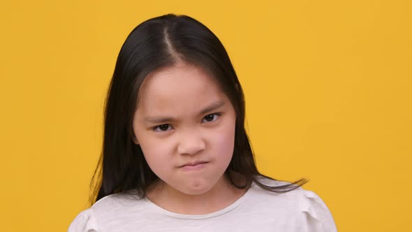 Little Grumpy Asian Girl Pouting Lips Grimacing and Looking Angrily to Camera Close Up Portrait