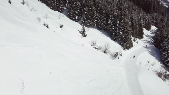 Aerial drone shot of snowy landscape, pathway in skiing area of Kleinwalsertal in the alps, Austria