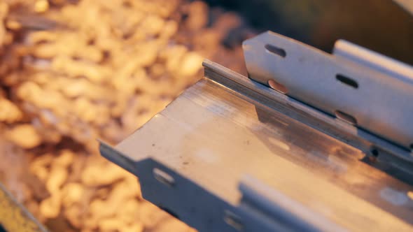 Close Up of a Metal Conveyor Releasing Copper Pieces Fast
