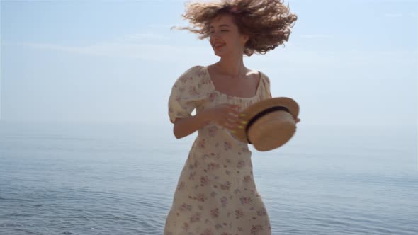 Laughing Woman Spinning Playing with Straw Hat on Beach