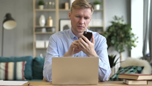 Businessman Using Smartphone at Office Workplace