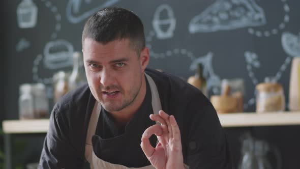 Male Chef Adding Seasonings to Toasts and Talking at Camera