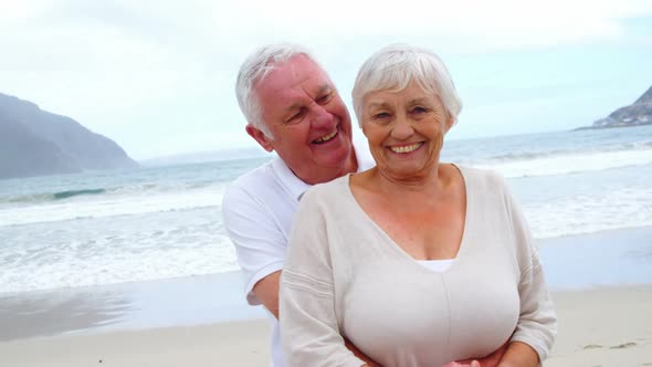 Senior couple embracing each other on the beach