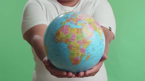 A Man In Front Of Green Screen Background Hand In The World Globe To The Camera