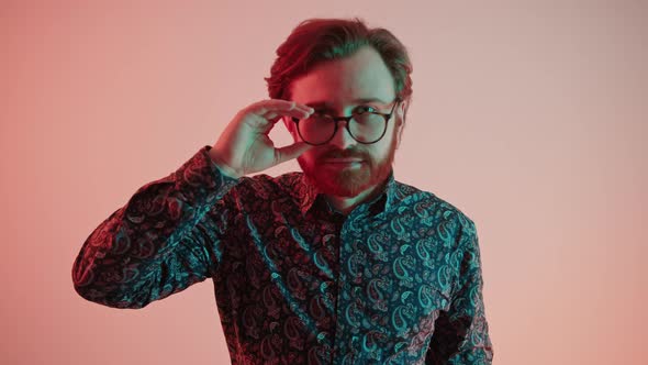 Handsome Caucasian Bearded Guy Touching His Modern Glasses with One Hand While Standing Over Salmon