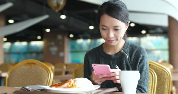 Busy woman use of mobile phone with her lunch