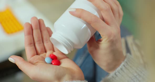 Colored Pills Fall on a Woman Palm From Bottle of Pills