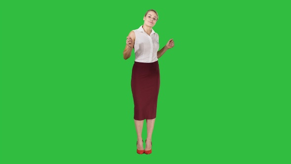 Beautiful happy young business woman dancing on a Green