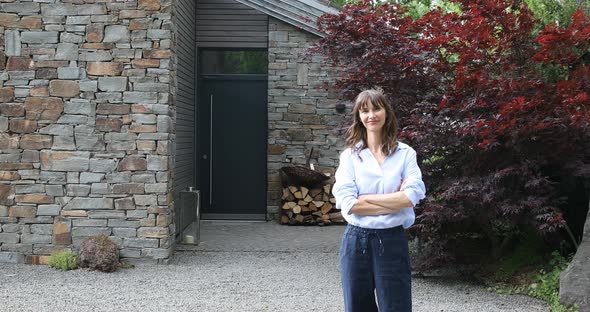 Smiling woman in front of her home