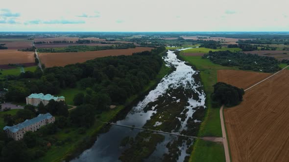 Mezotne Palace and Park With Fountain in Latvia. Lielupe River With Ponton Bridge Aerial 4K