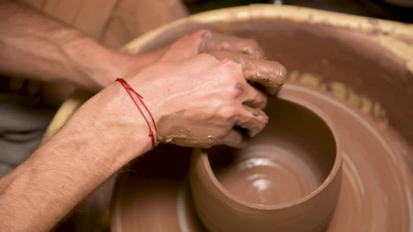 A Closeup of a Potter's Hand Creates a Clay Bowl on a Potter's Wheel