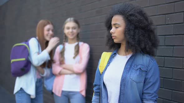 Two Female Students Laughing at Curly Afro-American Teenager, School Bullying