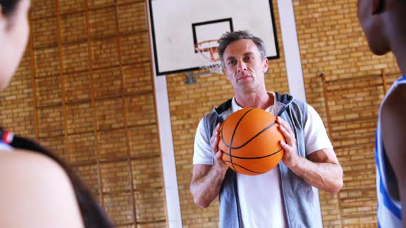 Coach assisting schoolkids in basketball 4k