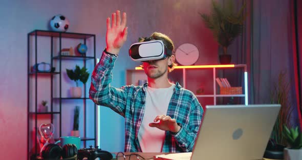 Guy in Virtual Reality Headset Working on Imaginary Display in Home Office