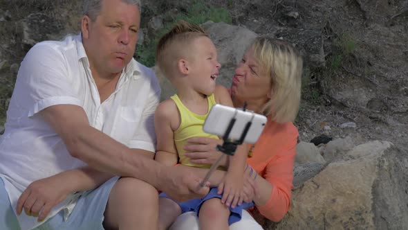 Grandparents and Grandchild Making Funny Mobile Selfie