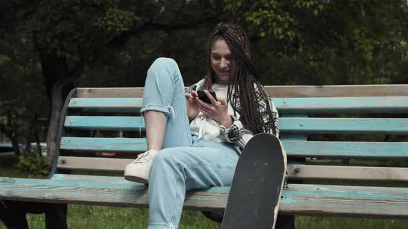 Cool skater girl texting outdoors.