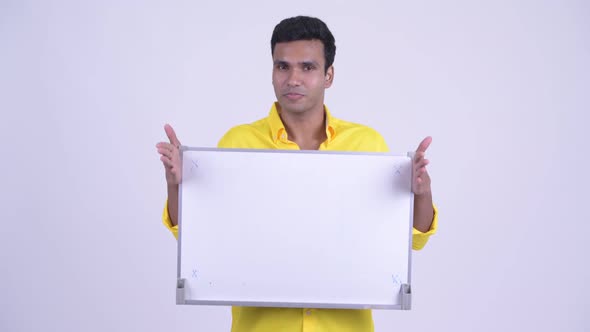 Happy Young Indian Businessman Talking While Holding White Board