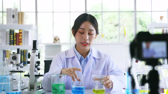 Asian Woman in Labcoat Record Online Video on Medical Research and Science Experiments in Laboratory