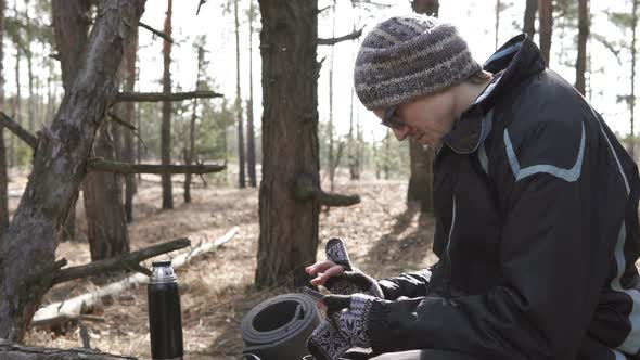 A tourist on a walk in a forest park looks at a map on a smartphone.